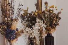 dried flower arrangements with grasses in various bottles and vases are cool for stylng your space for the fall