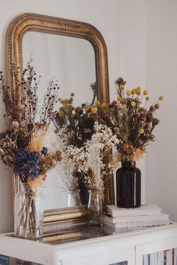 dried flower arrangements with grasses in various bottles and vases are cool for stylng your space for the fall