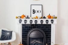 fun and bright Halloween mantel decor with gourds and pumpkins, candles, a banner and a chic sign, pumpkins on the floor