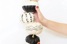 modern black and white Halloween pumpkins decorated with paint and a black sharpie are a great idea for a boho party