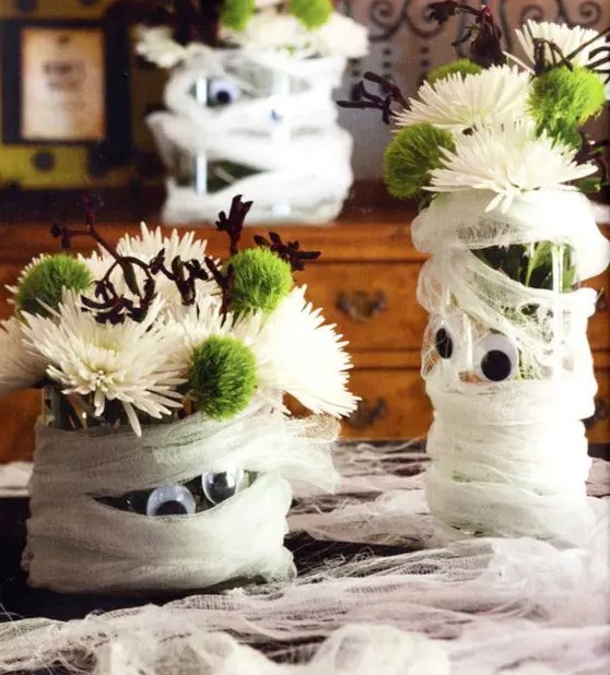 mummy styled planters with white and green blooms are adorable as Halloween centerpieces or just decorations