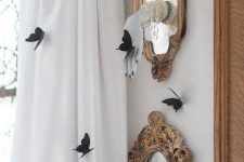 small mirrors in vintage frames with ghost hands and black butterflies around is a cool and bold idea