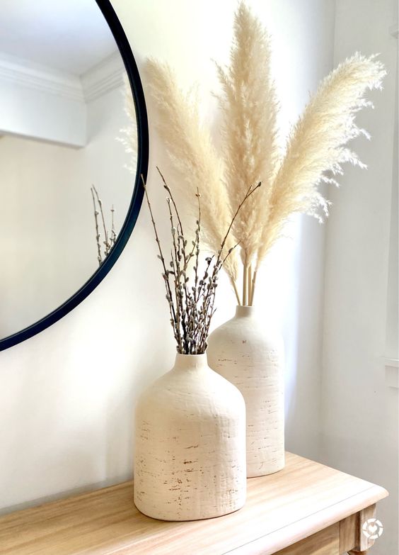 stylish and chic fall decor of two matching vases and pampas grass and twigs is ideal for a neutral boho interior
