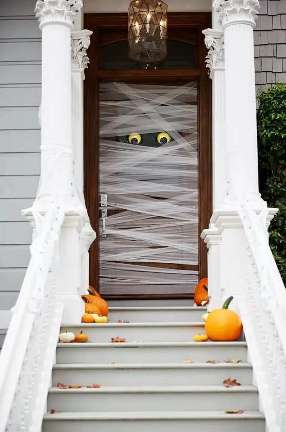 such a mummy-style front door is very easy to make, add a couple of pumpkins and fall leaves on the steps and voila - you have a Halloween porch