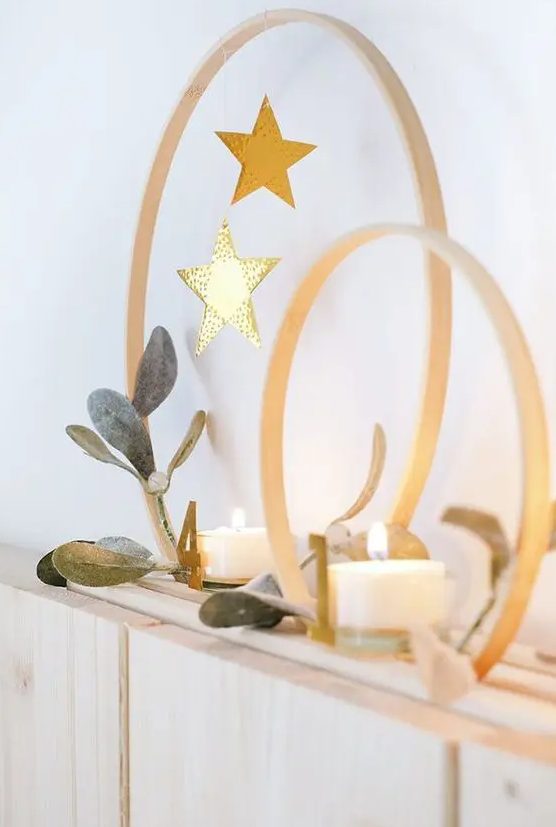 Christmas decor with embroidery hoops, candles and stars hanging down is a lovely modern decor idea