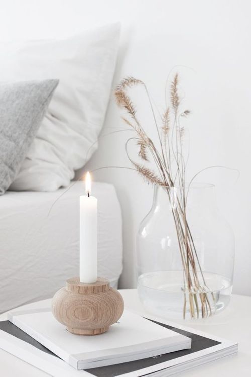 Nordic fall decor with a wooden candleholder with a candle, a clear vase and dried grasses is cool and simple