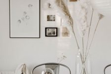 Scandinavian table decor with pampas grass in a clear vase, an artichoke, some branches in clear vases