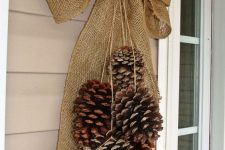 a Christmas posie with oversized pinecones and a burlap bow is a cool rustic decoration instead of a wreath