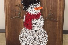 a Christmas string art piece with a snowman done with yarn is a very cool and fun decor idea to try