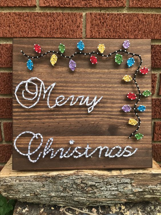 a Christmas string art piece with calligraphy and colorful lights is a cool decor idea for the holidays