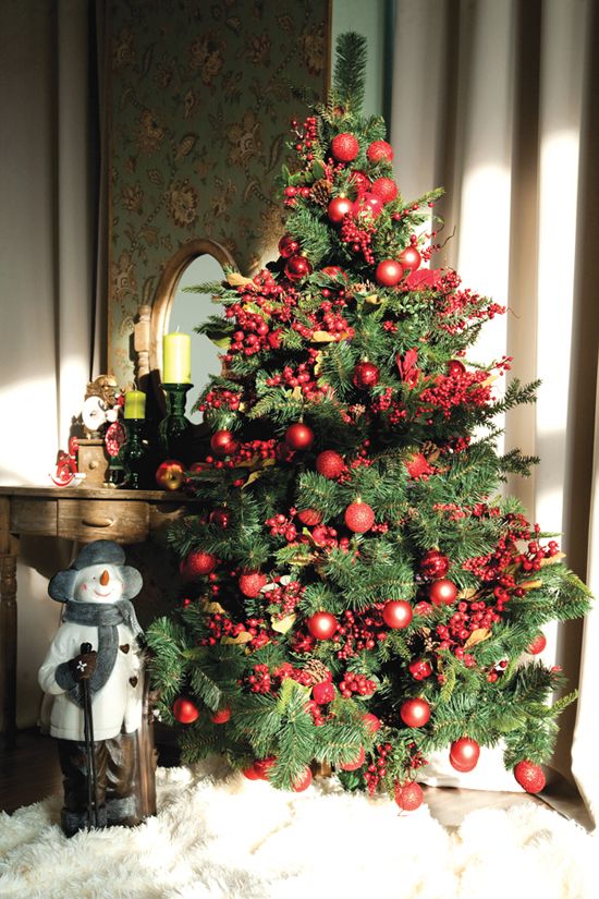 a Christmas tree decorated with berries and red ornaments is a very eye-catchy and bold solution for the holidays