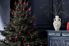 a Christmas tree with red ornaments is a cool and catchy idea, and absence of other decor gives it a modern feel
