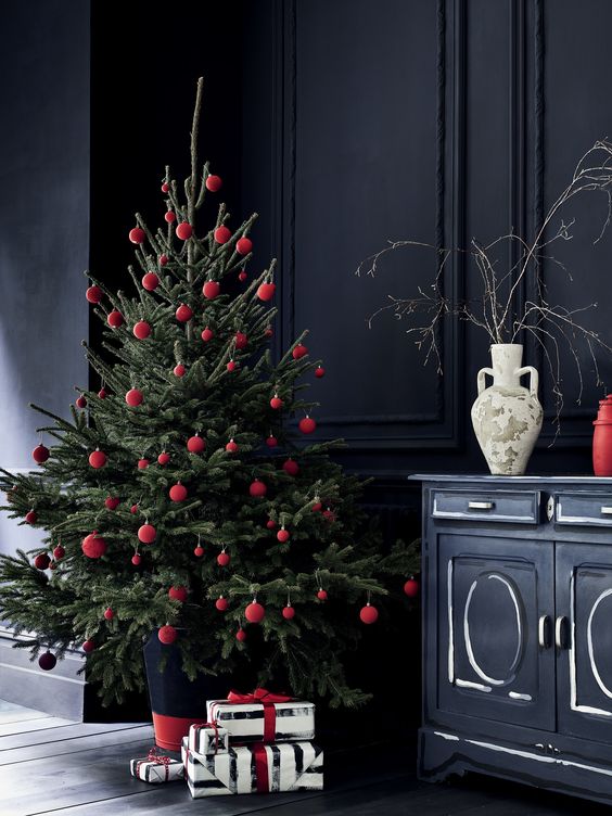 a Christmas tree with red ornaments is a cool and catchy idea, and absence of other decor gives it a modern feel