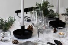 a Nordic Christmas table with neutral linens, white candles, pinecones, evergreens for a cozy Christmas dinner