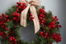 a beautiful Christmas wreath of pinecones, evergreens, berries and a printed bow on top is cool