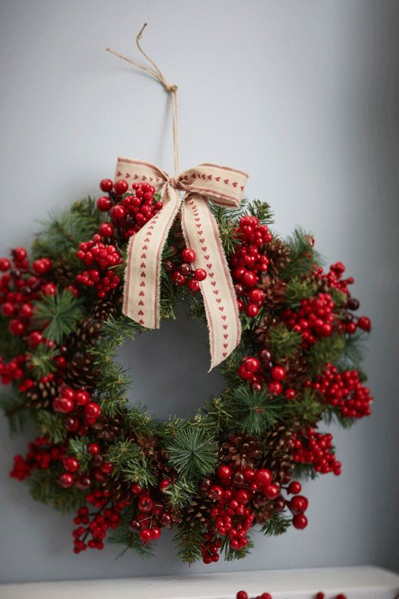 a beautiful Christmas wreath of pinecones, evergreens, berries and a printed bow on top is cool