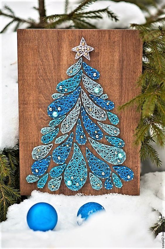 a blue string art piece showing a Christmas tree of drops, with pearls instead of ornaments is cool