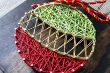 a bright Christmas ornament string art in green and red and with a yarn bow is a cool and catchy idea
