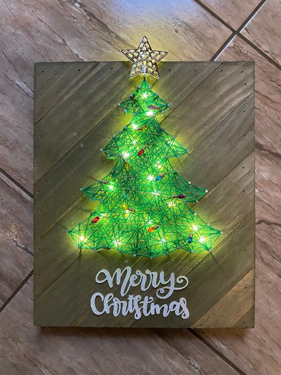 a bright Christmas string art piece showing a green tree with tiny lights and a star topper is a cool idea