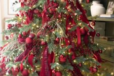 a bright Christmas tree decorated with red ornaments, red ribbons and berries plus lights is amazing for the holidays