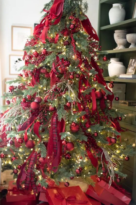 a bright Christmas tree decorated with red ornaments, red ribbons and berries plus lights is amazing for the holidays