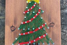 a bright holiday string art done with brown, green, red and yellow yarn, is a cool solution for Christmas spaces