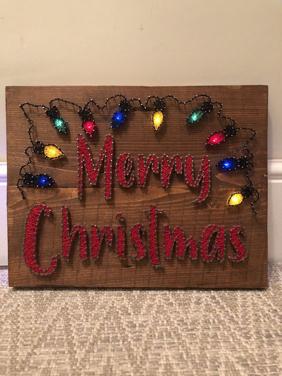 a bright holiday string art piece with letters and colorful lights done with lights is super cool
