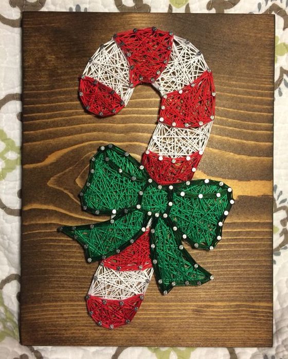 a candy can Christmas string art in red, green and white is a cool decor idea in traditional Christmassy colors