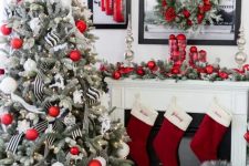 a chic Christmas space with red stockings, a Christmas tree decorated with silver, white and red ornaments, red ornaments on the mantel and in the wreath