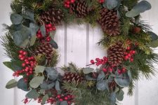 a classic rustic Christmas wreath of evergreens, eucalyptus, red berries and pinecones is a lovely decoration