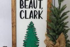 a cool Christmas sign with letters, a green tree and a stained wooden frame is a cool farmhouse or rustic decor idea