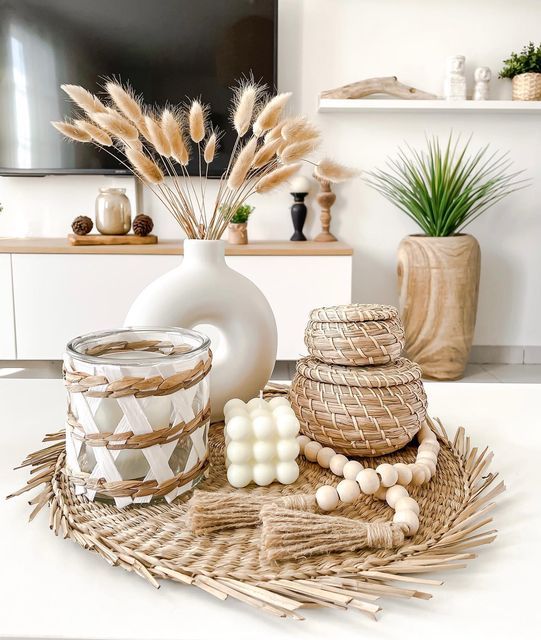 a fall Scandinavian arrangement with a woven tray, a candle, some woven mini boxes, a vase with bunny tails