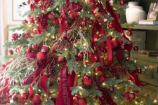a fantastic Christmas tree decorated with red and red plaid ribbons, ornaments and lights is wow