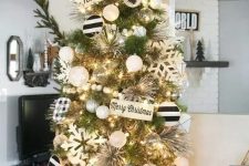 a farmhouse Christmas tree with white, silver, pearly and black and white ornaments, large snowflakes and signs plus wooden beads