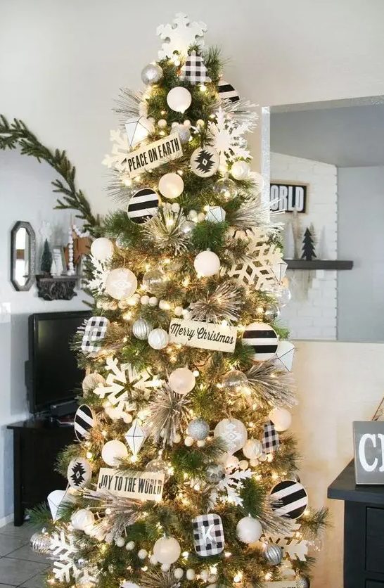 a farmhouse Christmas tree with white, silver, pearly and black and white ornaments, large snowflakes and signs plus wooden beads