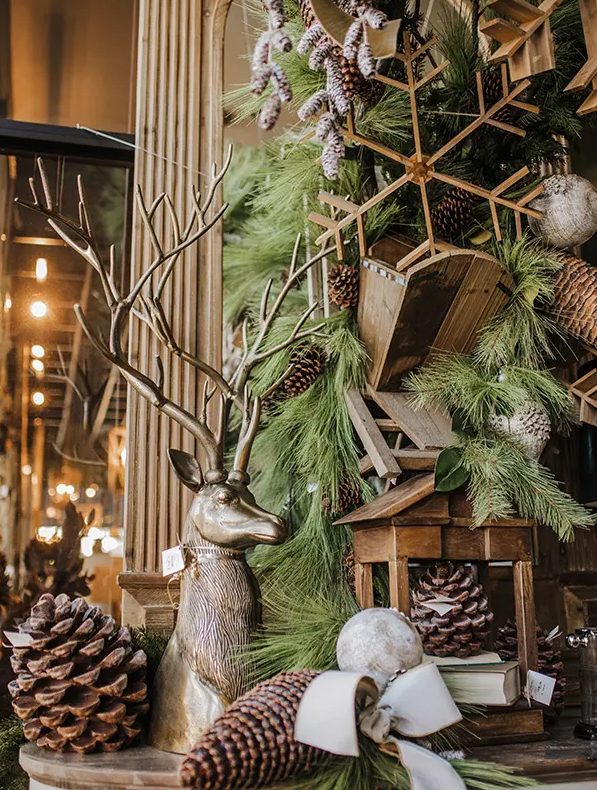 a gorgeous woodland Christmas tree all covered with pinecones, wooden snowflakes, a wooden candleholder and lots of large pinecones around