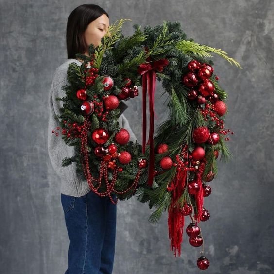 a jaw-dropping large Christmas wreath with red ornaments, evergreens and beads in red is amazing
