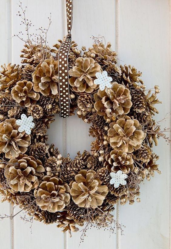 a lovely Christmas wreath with white flowers and twigs plus a polka dot ribbon is a cool decoration for Christmas
