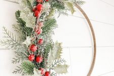 a lovely embroidery hoop Christmas wreath with snowy leaves, greenery, berries is a beautiful solution for outdoor decor