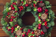 a luxurious Christmas wreath of evergreens, pinecones, berries os a catchy and cool idea for bold holiday decor