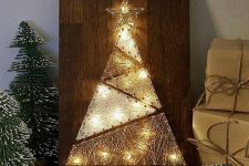 a modern Christmas string art piece showing a tree composed of triangles, with a star topper and lights is adorable