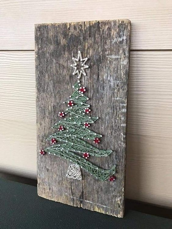 a piece of reclaiemd wood got a new life with a string art showing a lovely Christmas tree with red ornaments