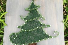 a pretty Christmas string art showing a creative Christmas tree, done with yarn of muted colors, is a cool decoration