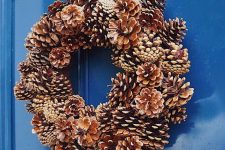 a pretty pinecone Christmas wreath with a bold bow on top is a lovely decoration that you can make yourself