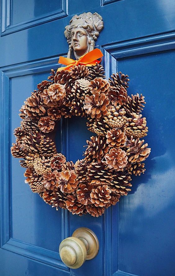 a pretty pinecone Christmas wreath with a bold bow on top is a lovely decoration that you can make yourself
