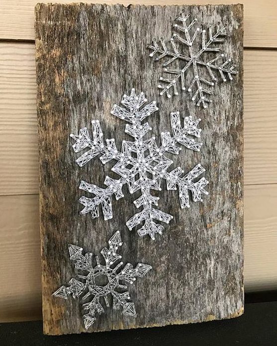 a reclaimed wood piece with string art silver snowflakes looks very cool as reclaimed wood adds interest and texture