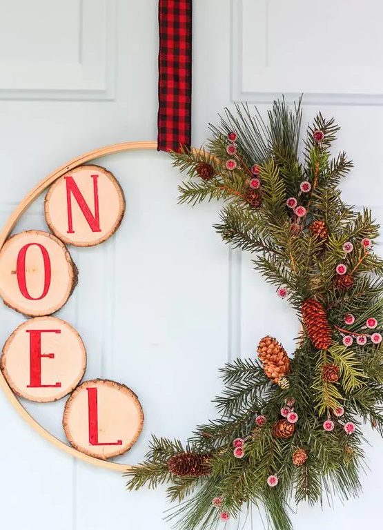a rustic Christmas wreath with evegreens, berries and pinecones, tree slices with red letters and a plaid ribbon on top