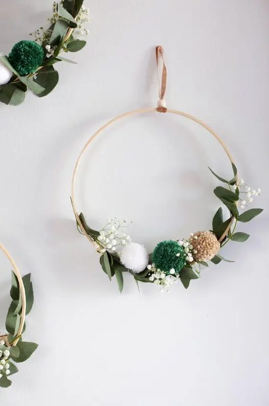 a simple and lovely Christmas embroidery hoop wreath with greenery, baby's breath and pompoms is a lovely decoration for the holidays