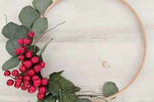 a simple and quick to make Christmas wreath decorated with greenery and bold red berries is a lovely decoration