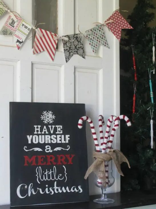 a simple black Christmas sign with white and red letters is a stylish idea for more modern holiday decor and styling